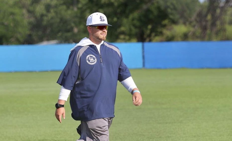 Coach Niko Gonzalez walking the field in a navy pullover